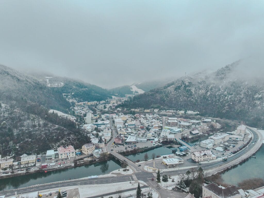 Aerial winter cityscape of Lilienfeld, Austria with snow-covered mountains and town.