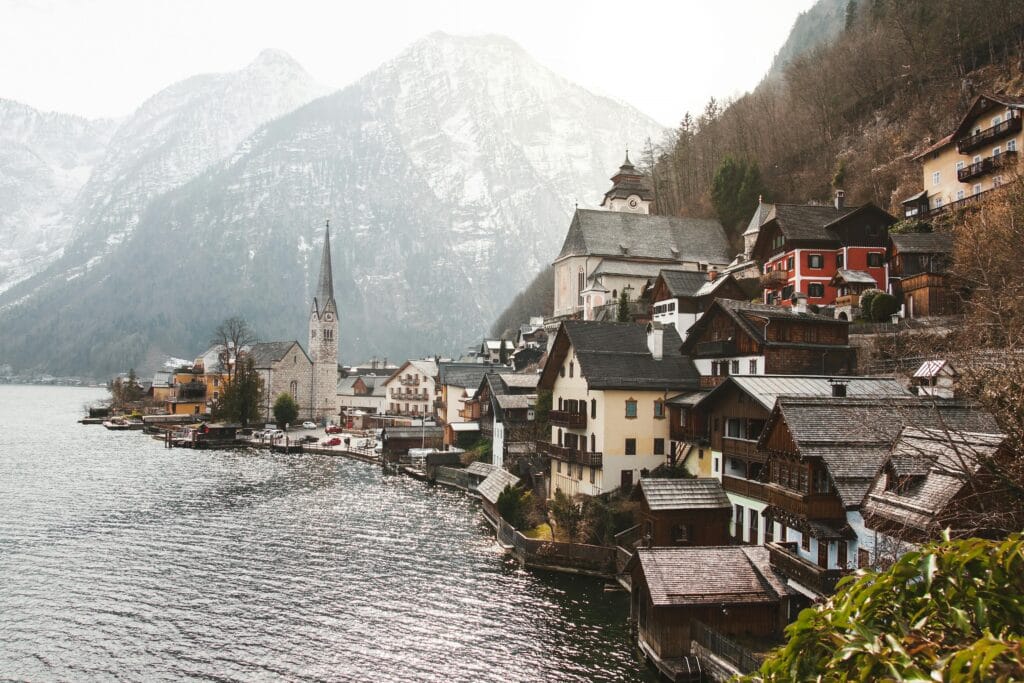 Charming winter scene of Hallstatt village, lakeside with mountains.