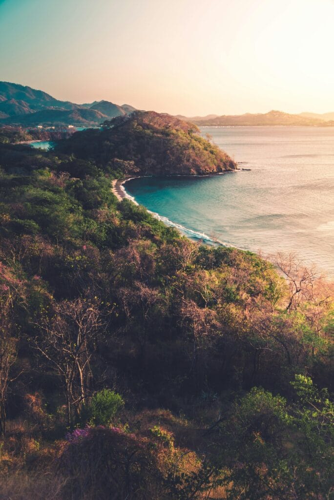 Breathtaking view of a lush peninsula meeting the ocean under a warm sunset in Costa Rica.