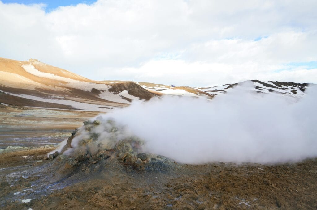 Captivating view of steam rising from a geothermal vent in Iceland's rugged landscape.