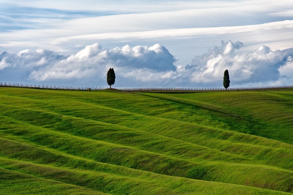 Beautiful rolling hills in Tuscany, Italy with dramatic clouds in the background.